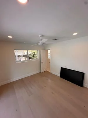 Renovated room with recessed lighting, ceiling fan, new flooring, and painted drywall