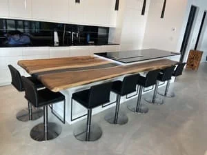 Live-edge wood dining table with resin inlay, polished concrete floors, black bar seating