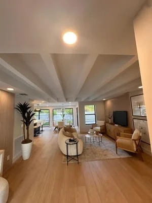 Modern living room with coffered ceiling, hardwood floors, and recessed lighting